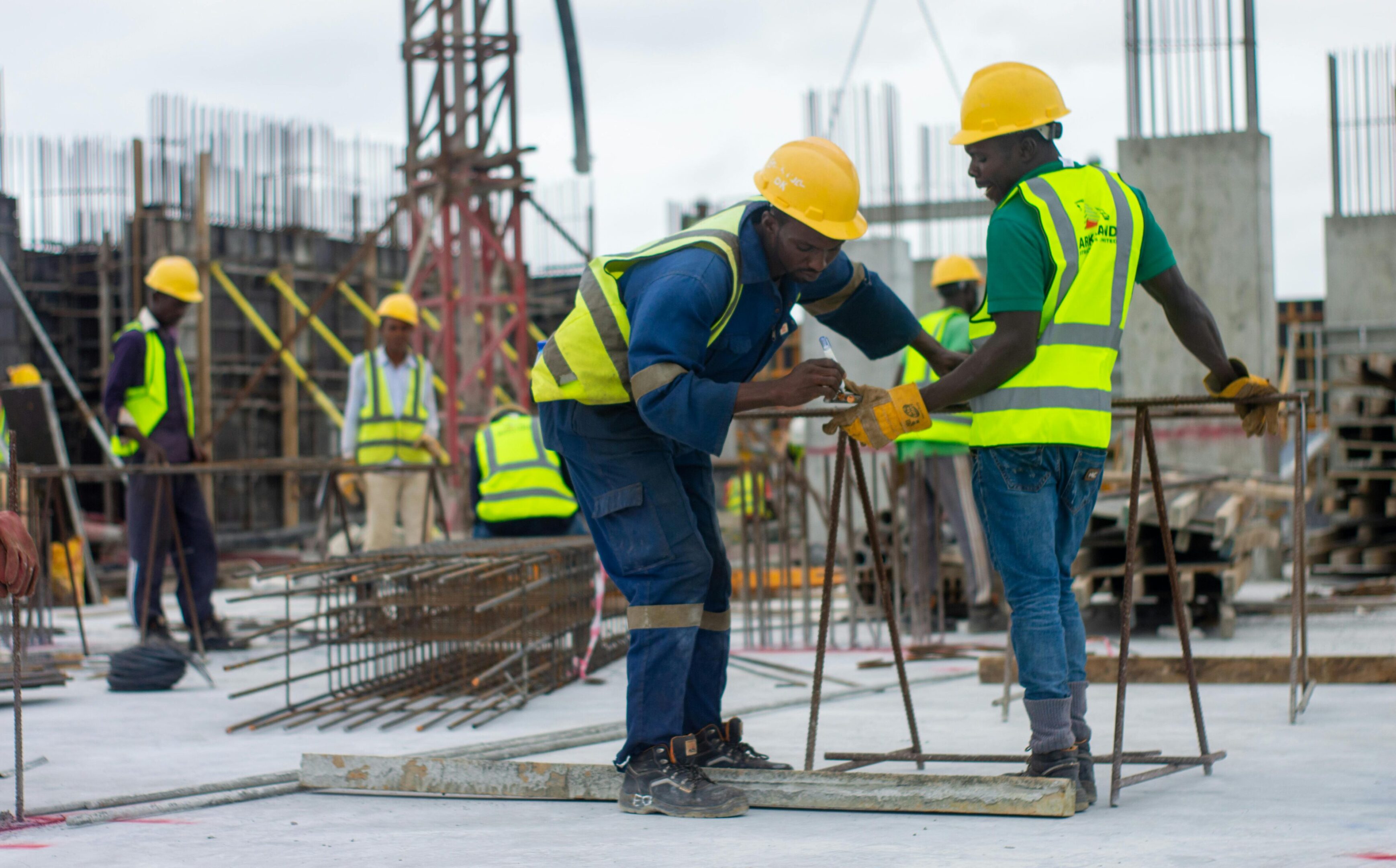 Construction workers in hard hats tying rebar