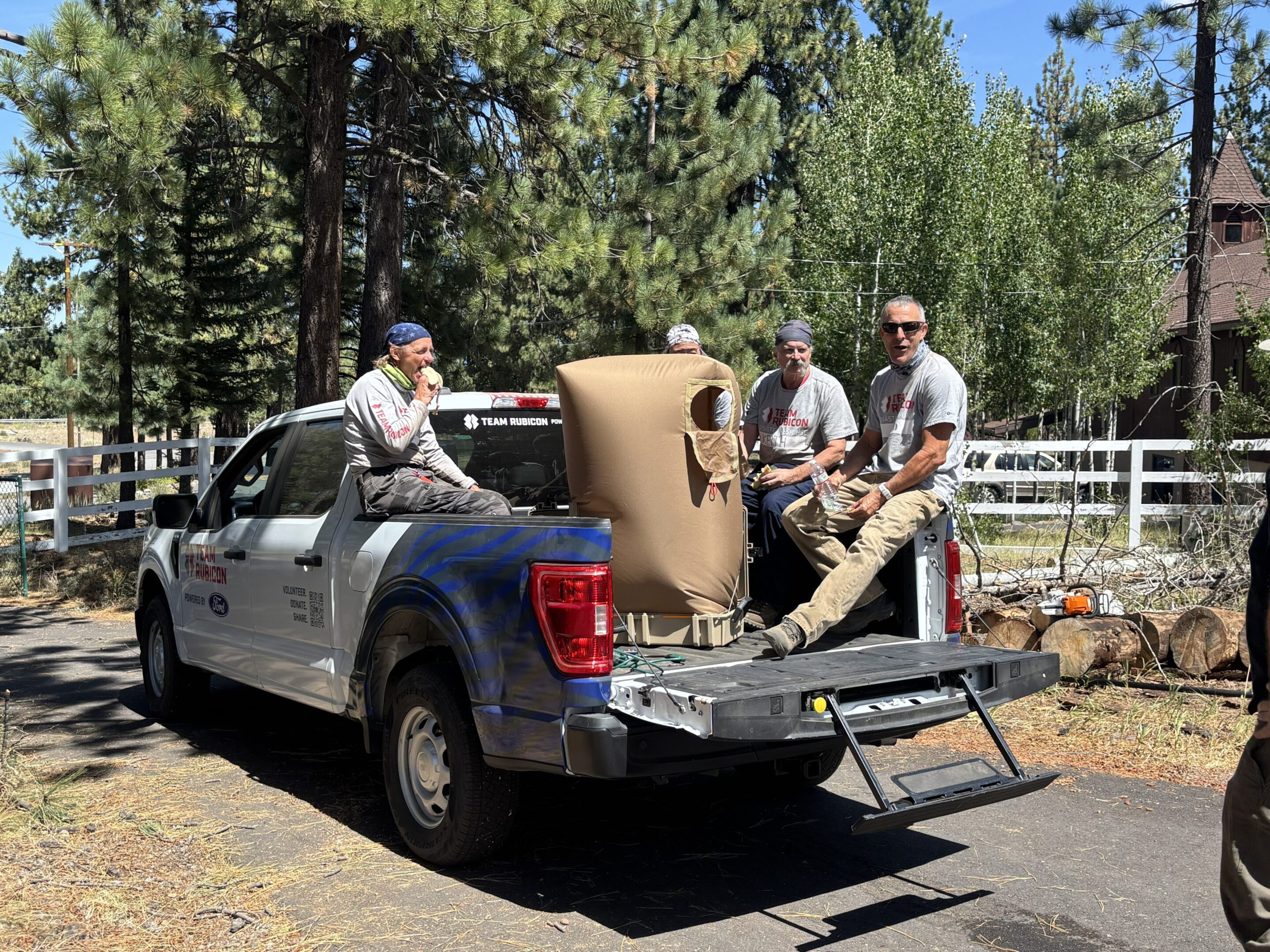 Crew sitting on pickup truck with wrapped furniture